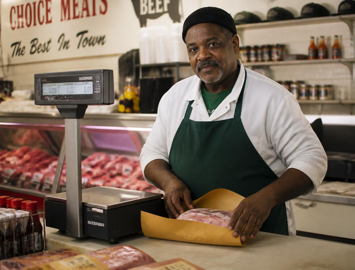 A bright meat counter with fresh cuts of beef, pork and poultry arranged behind clean glass.